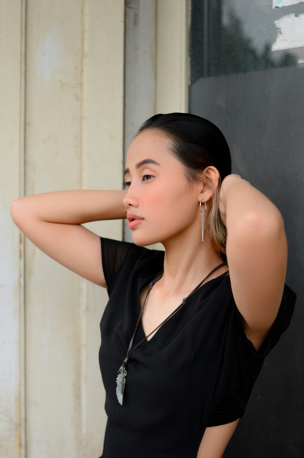 a woman leaning against a wall with her hand on her head