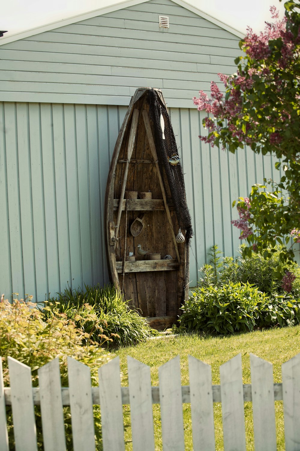 a wooden boat sitting on top of a lush green field