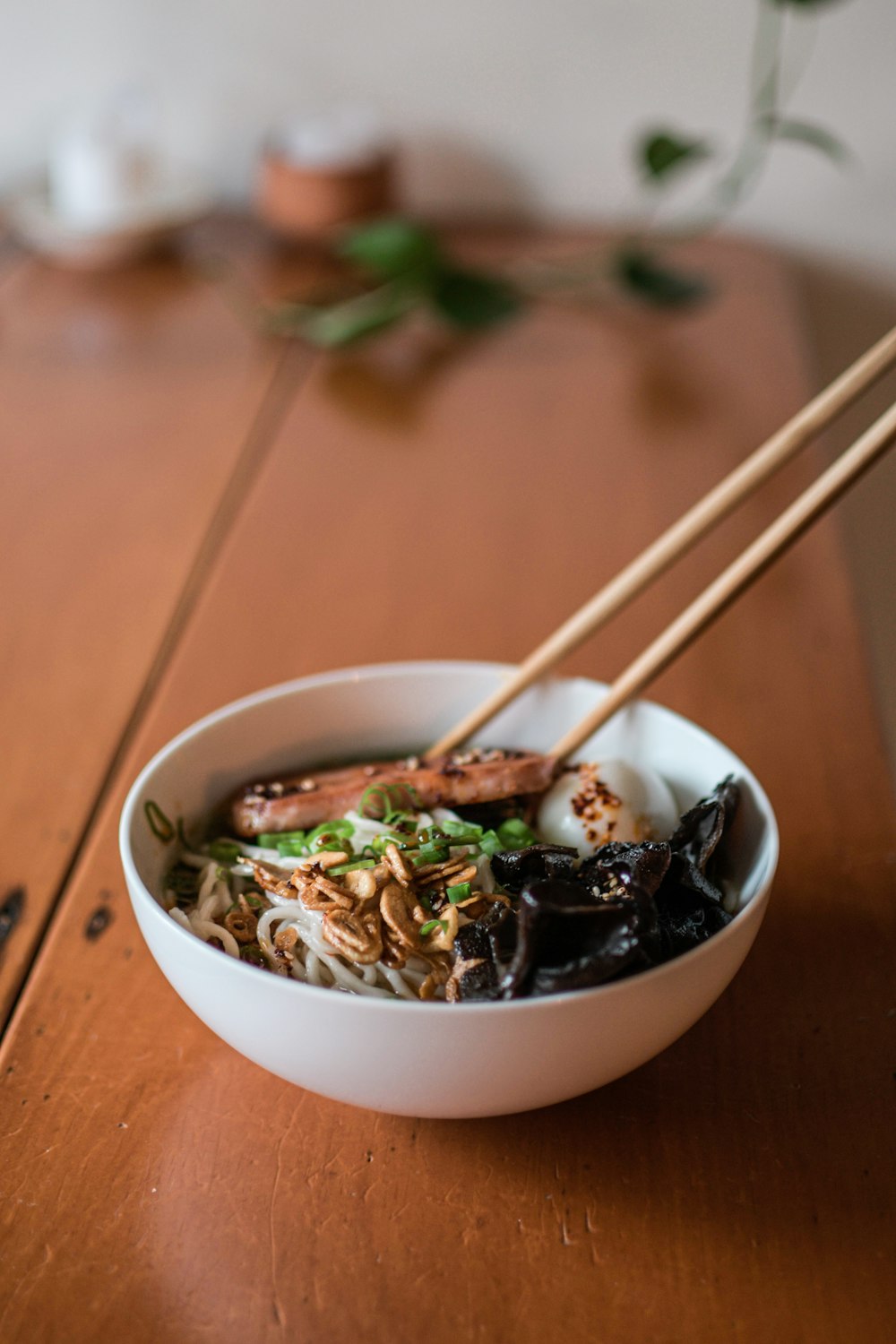 a bowl of food with chopsticks on a table