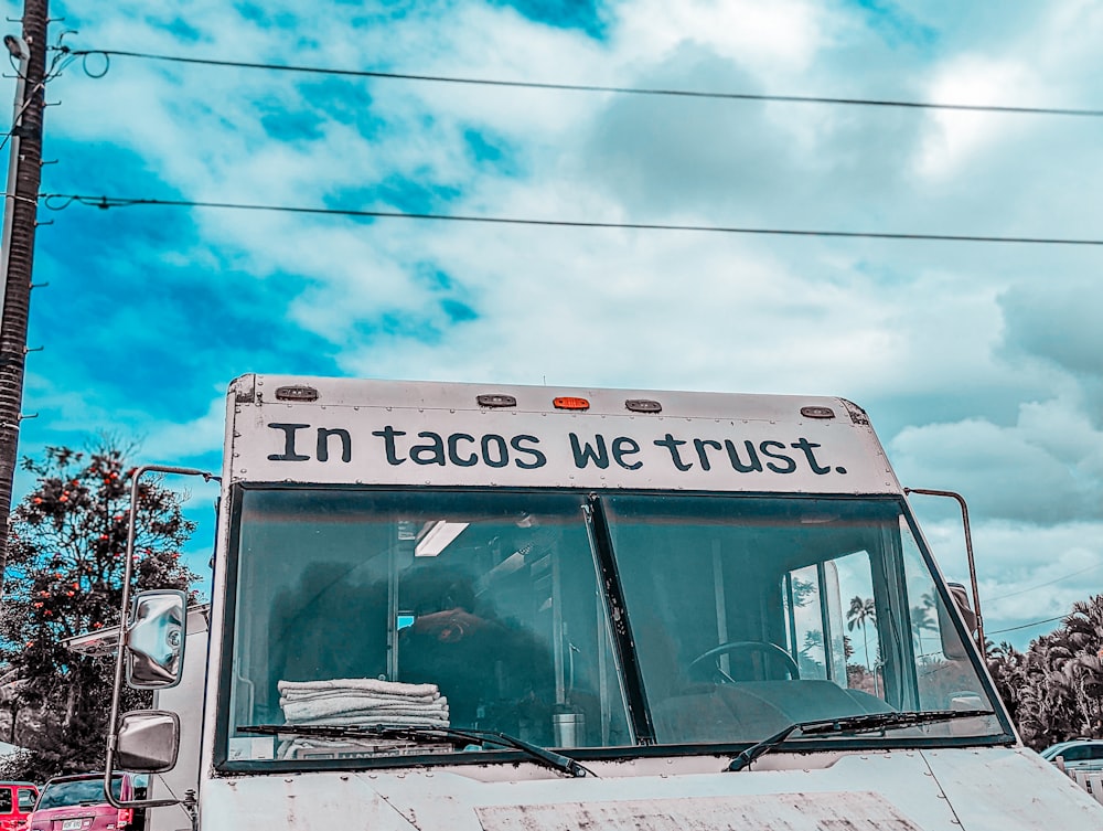 a white truck with the words in tacos we trust written on it