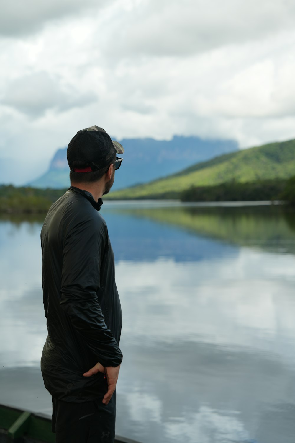 a man standing next to a body of water