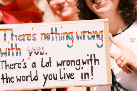 a woman holding a sign that says there's nothing wrong with you
