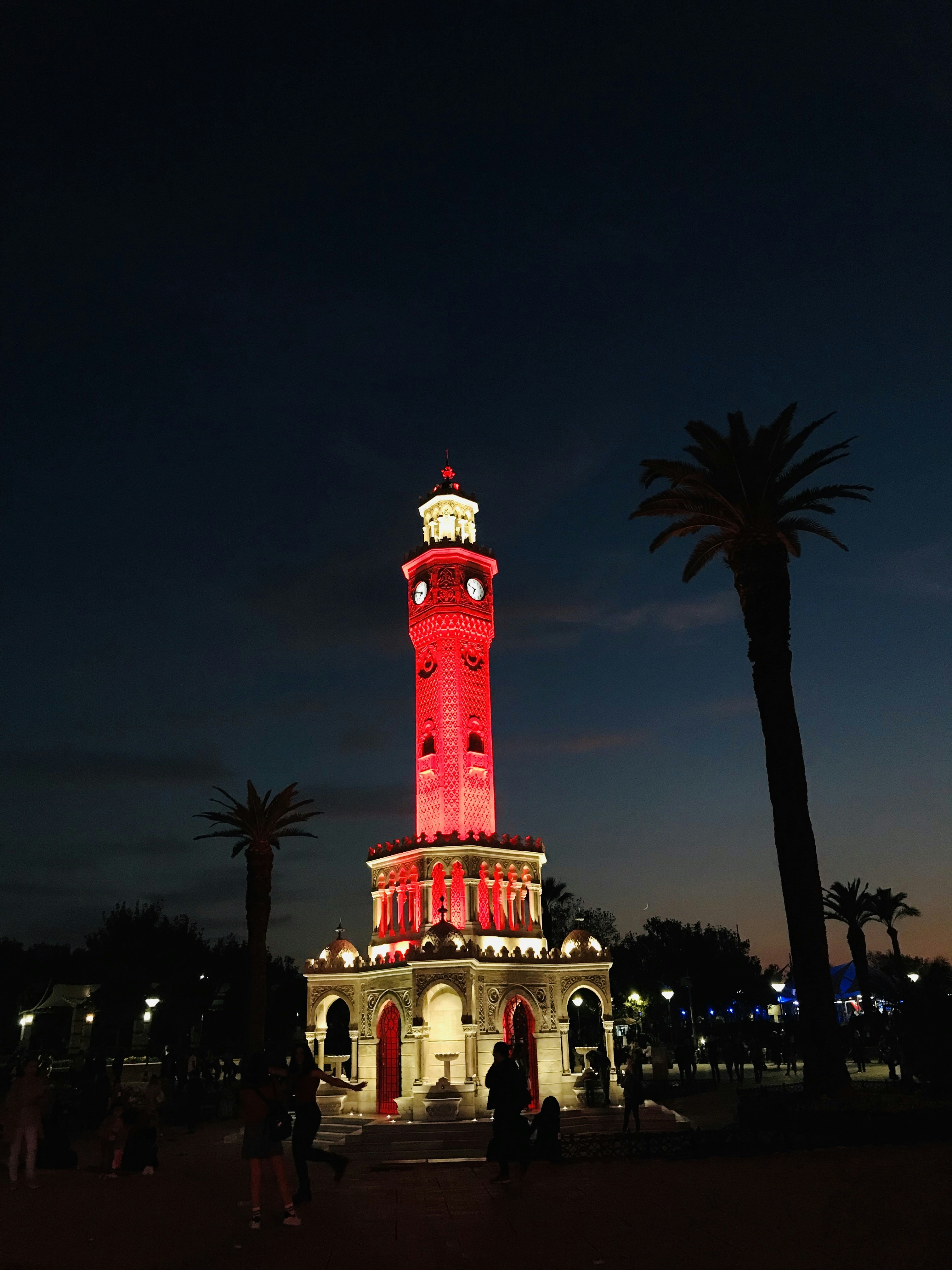 a red and white clock tower lit up at night