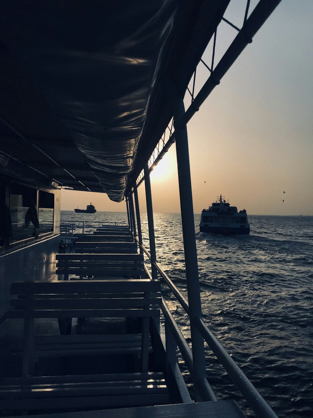 the sun is setting on a boat in the ocean