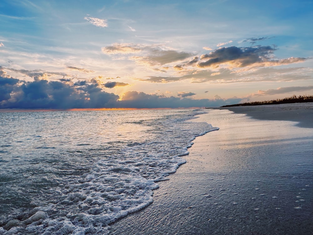 Le soleil se couche sur l’eau à la plage