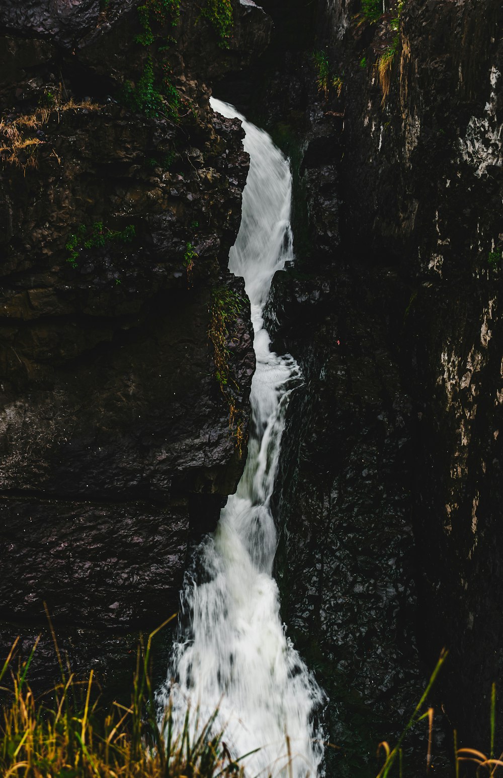 a waterfall flowing down a rocky cliff into a body of water