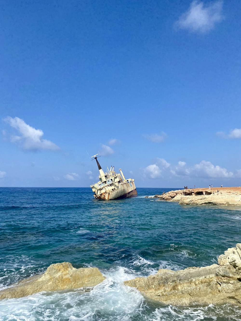 a ship in the water off the coast of a beach