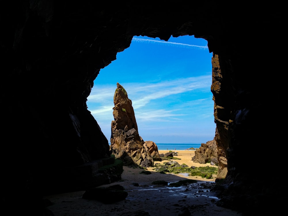 a view of a beach through a cave