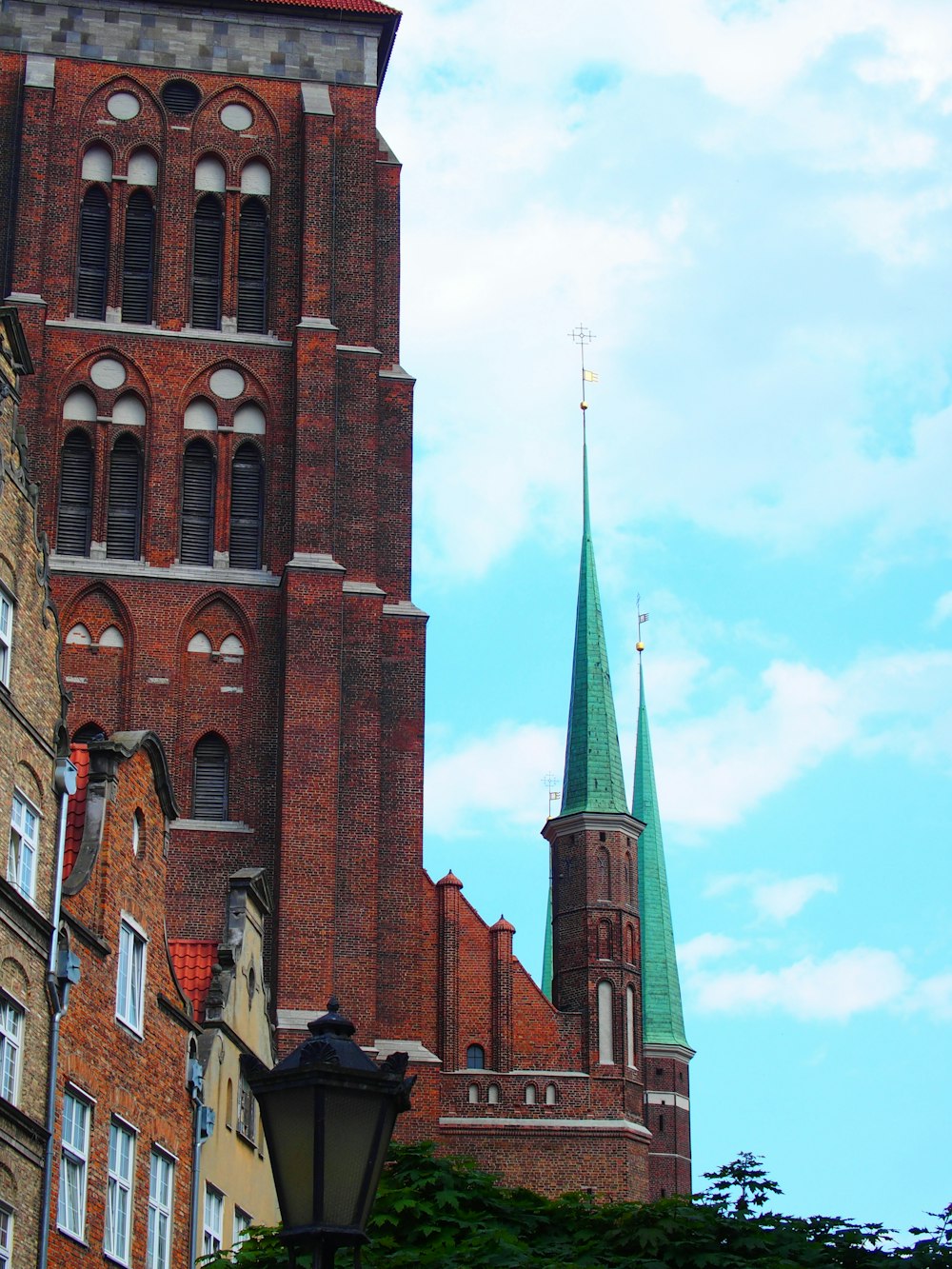 a tall brick building with a green steeple