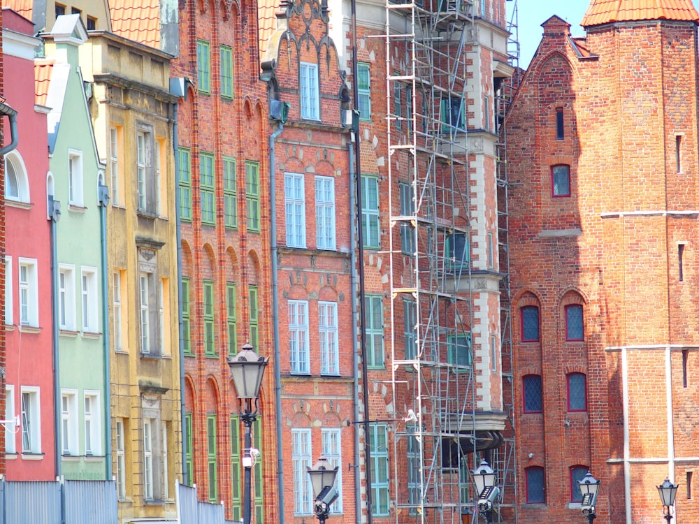 a row of buildings with scaffolding on the windows