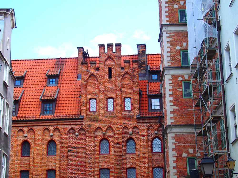 a tall brick building with a red tiled roof