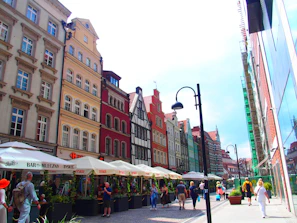 A vibrant street scene in Leuven with colorful historic buildings and lively cafes under a bright sky