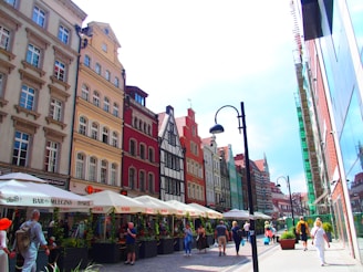 A vibrant city street scene outside a boutique hotel, showcasing diverse architecture and lively atmosphere.