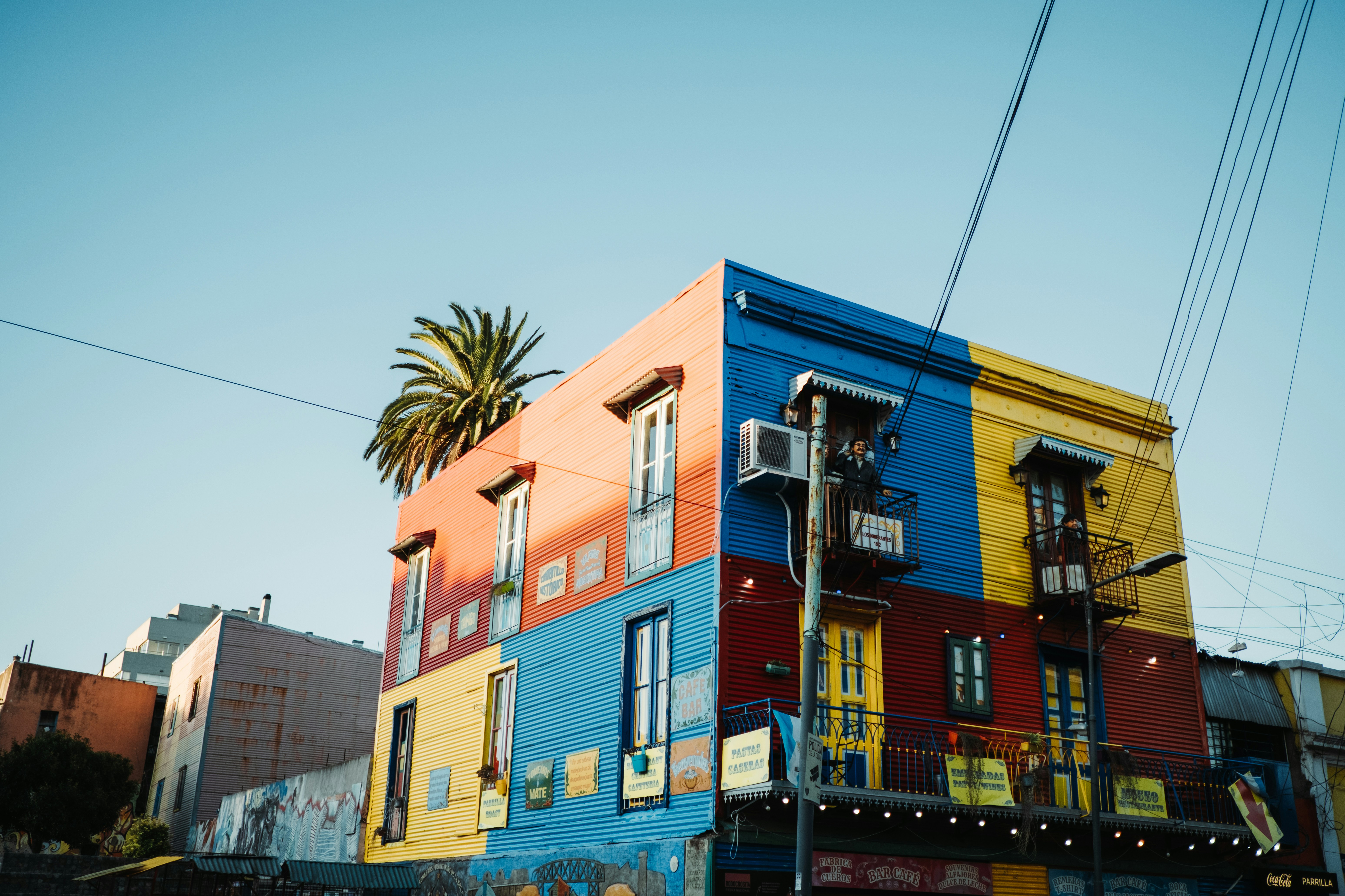 A multi - colored building with a palm tree in front of it photo – Free ...