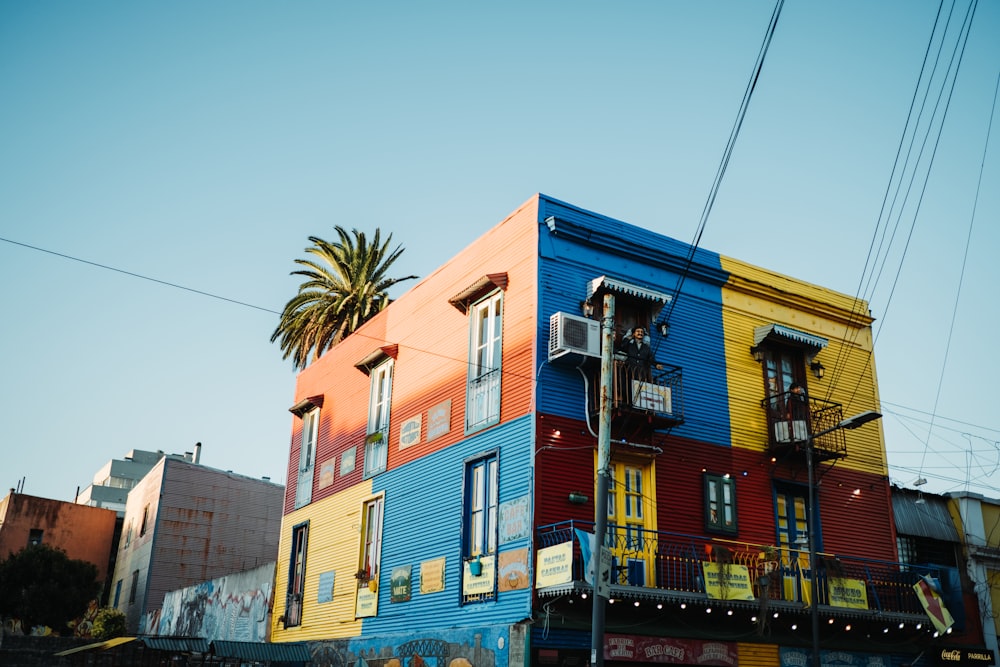 a multi - colored building with a palm tree in front of it