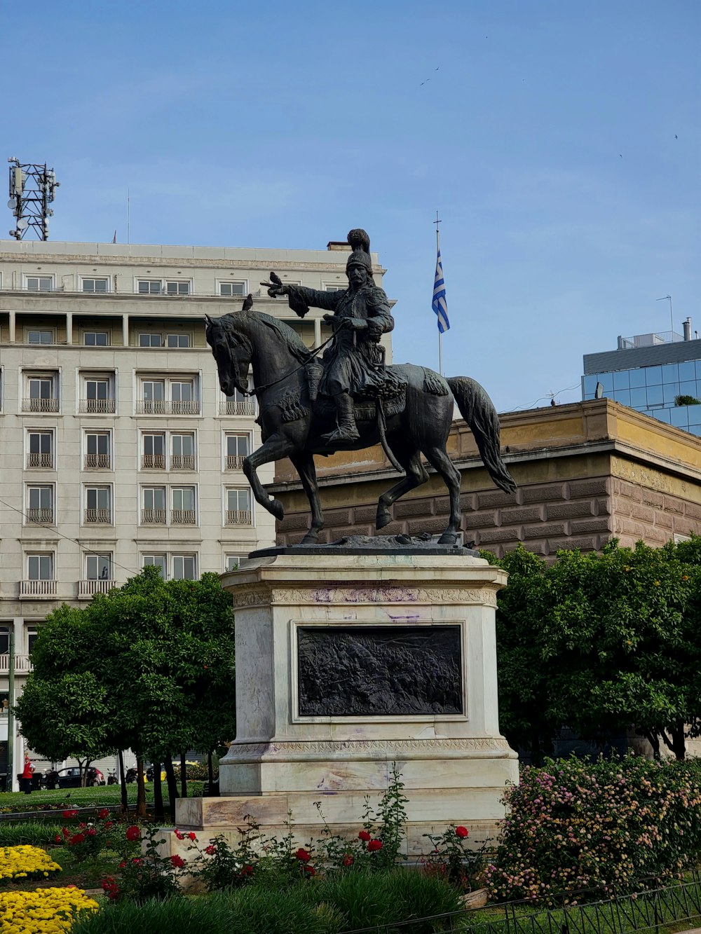 uma estátua de um homem em um cavalo na frente de um edifício