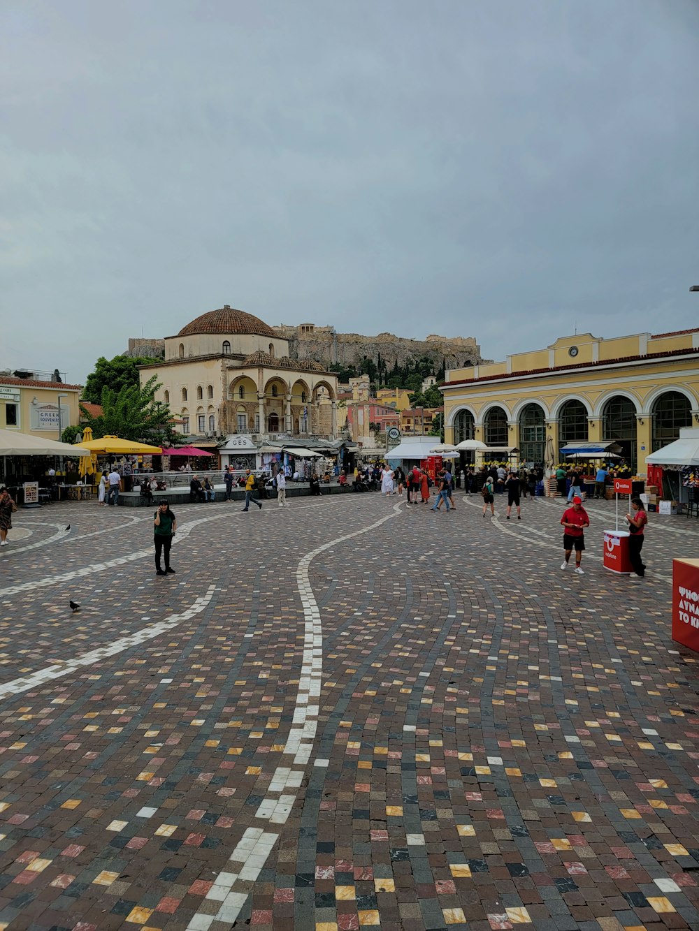 a group of people walking around a cobblestone street