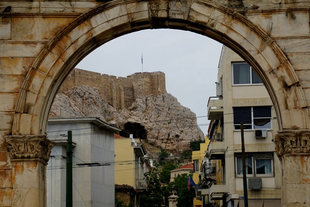 an arch in a stone building with a castle in the background