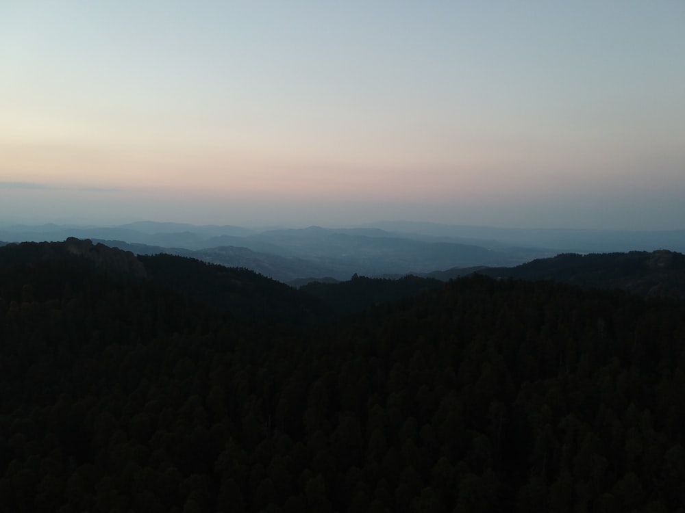 uma vista de uma cordilheira com árvores em primeiro plano