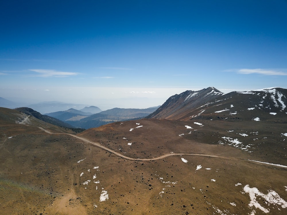 an aerial view of a dirt road in the mountains