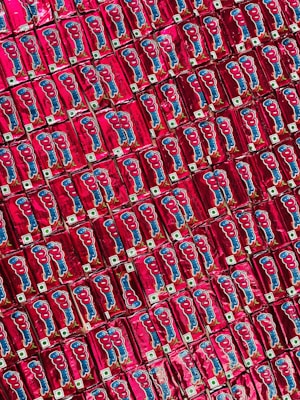 A repeated pattern of red packaged snacks with cartoon graphics and logos, neatly arranged side by side creating a colorful and symmetrical display.