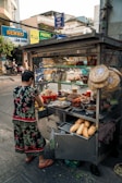a woman standing in front of a food cart