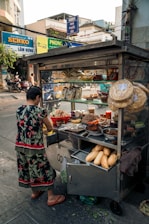 a woman standing in front of a food cart