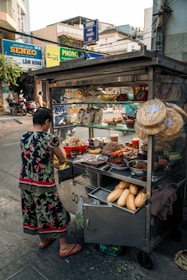 a woman standing in front of a food cart