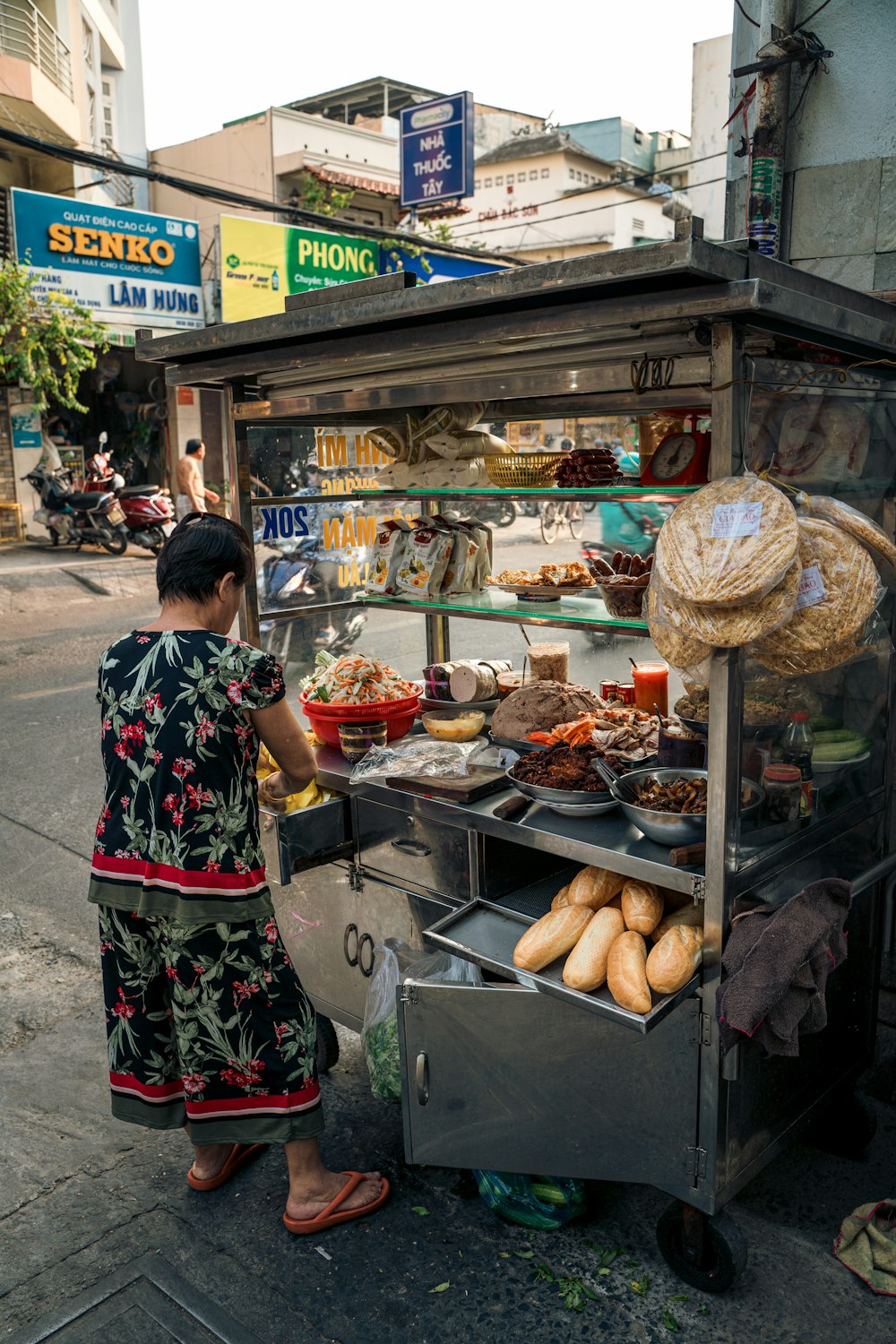 uma mulher em pé na frente de um carrinho de comida