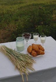 Rustic breakfast setup on a wooden table outdoors with fresh fruits and coffee.