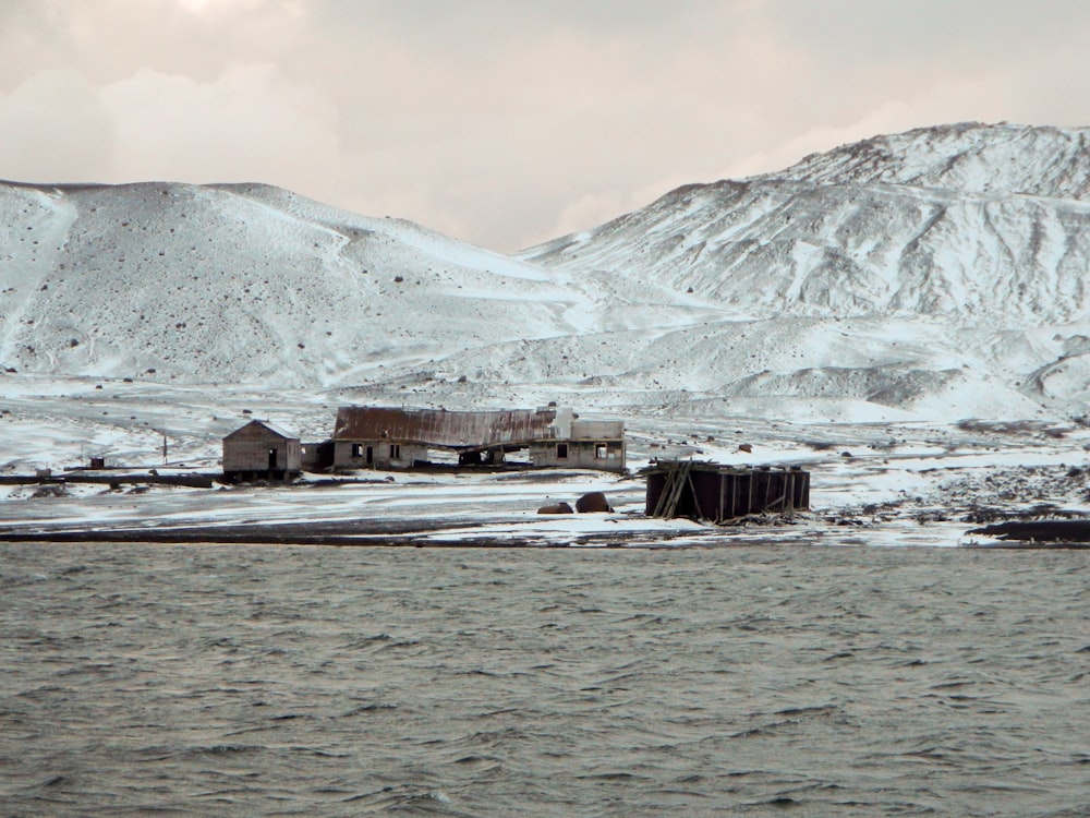 a snow covered mountain with a small shack in the foreground