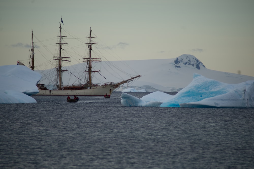 a ship sailing in the ocean near icebergs