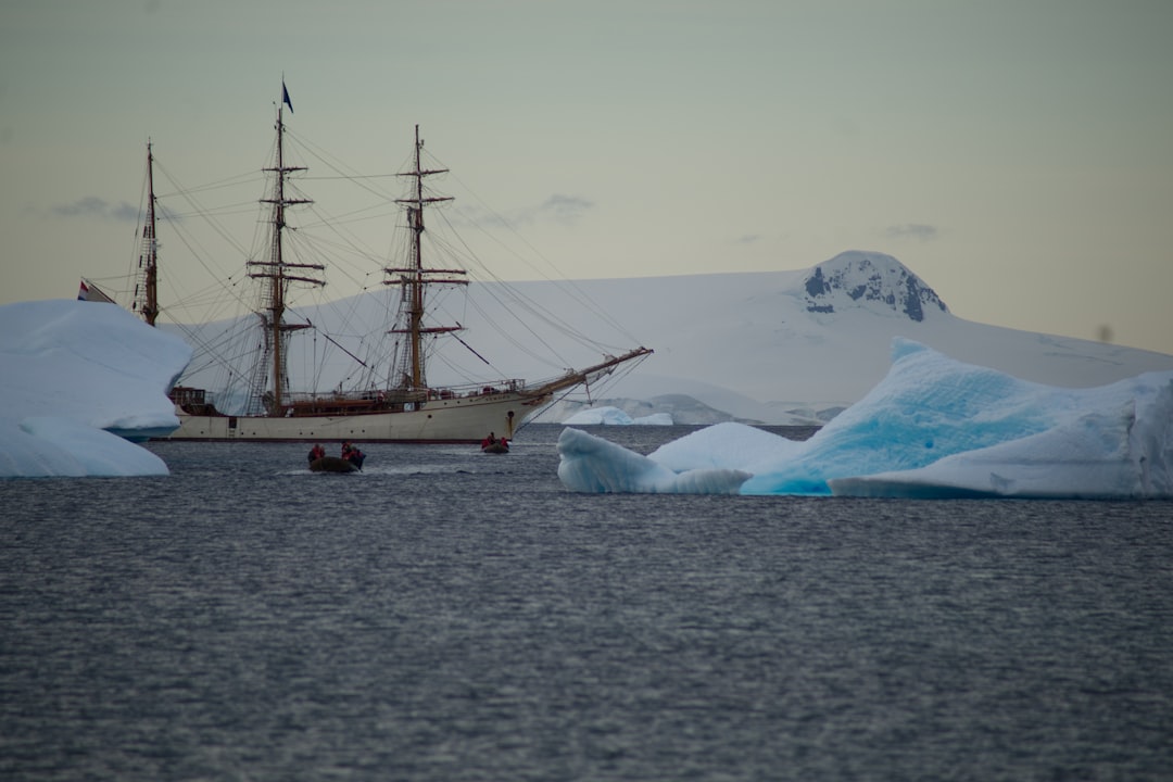 a ship sailing in the ocean near icebergs,