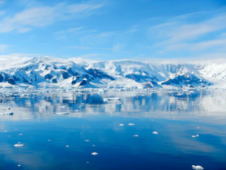 a large body of water surrounded by snow covered mountains