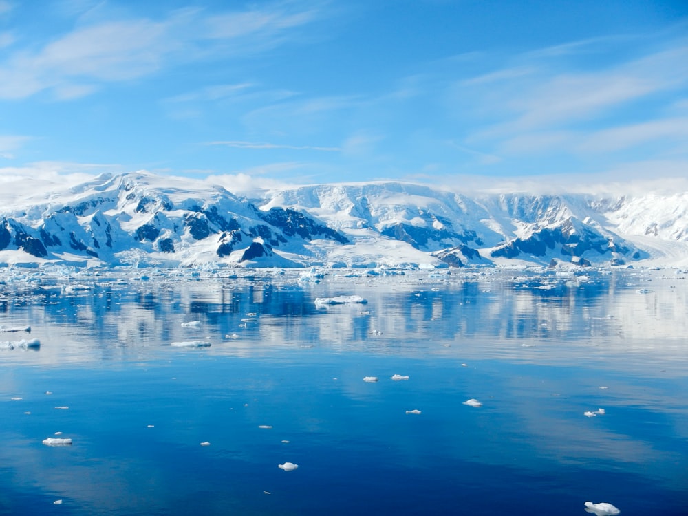 a large body of water surrounded by snow covered mountains