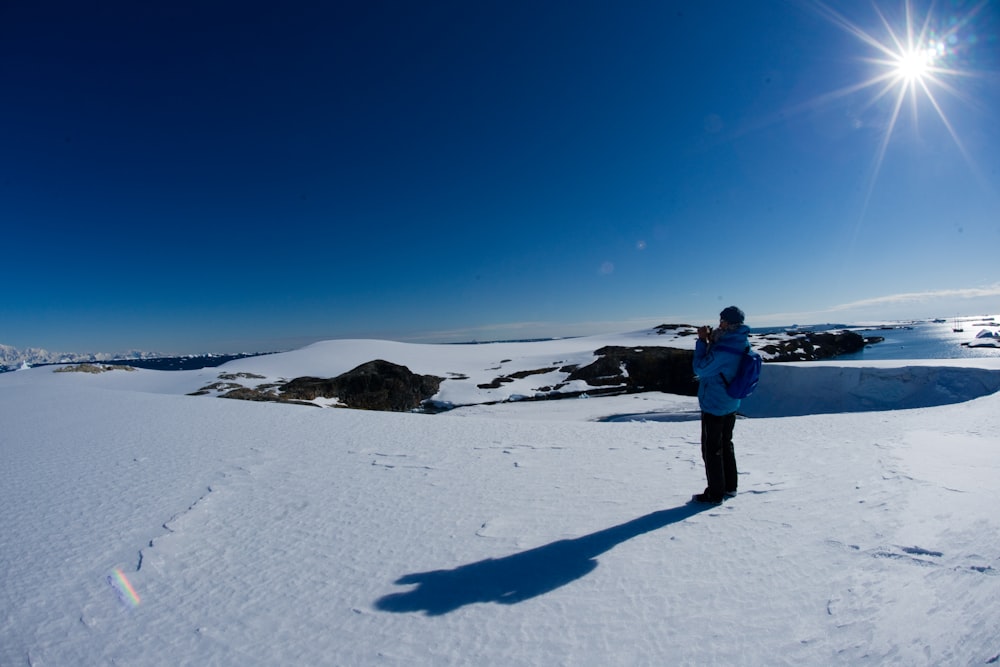 a man standing on top of a snow covered slope