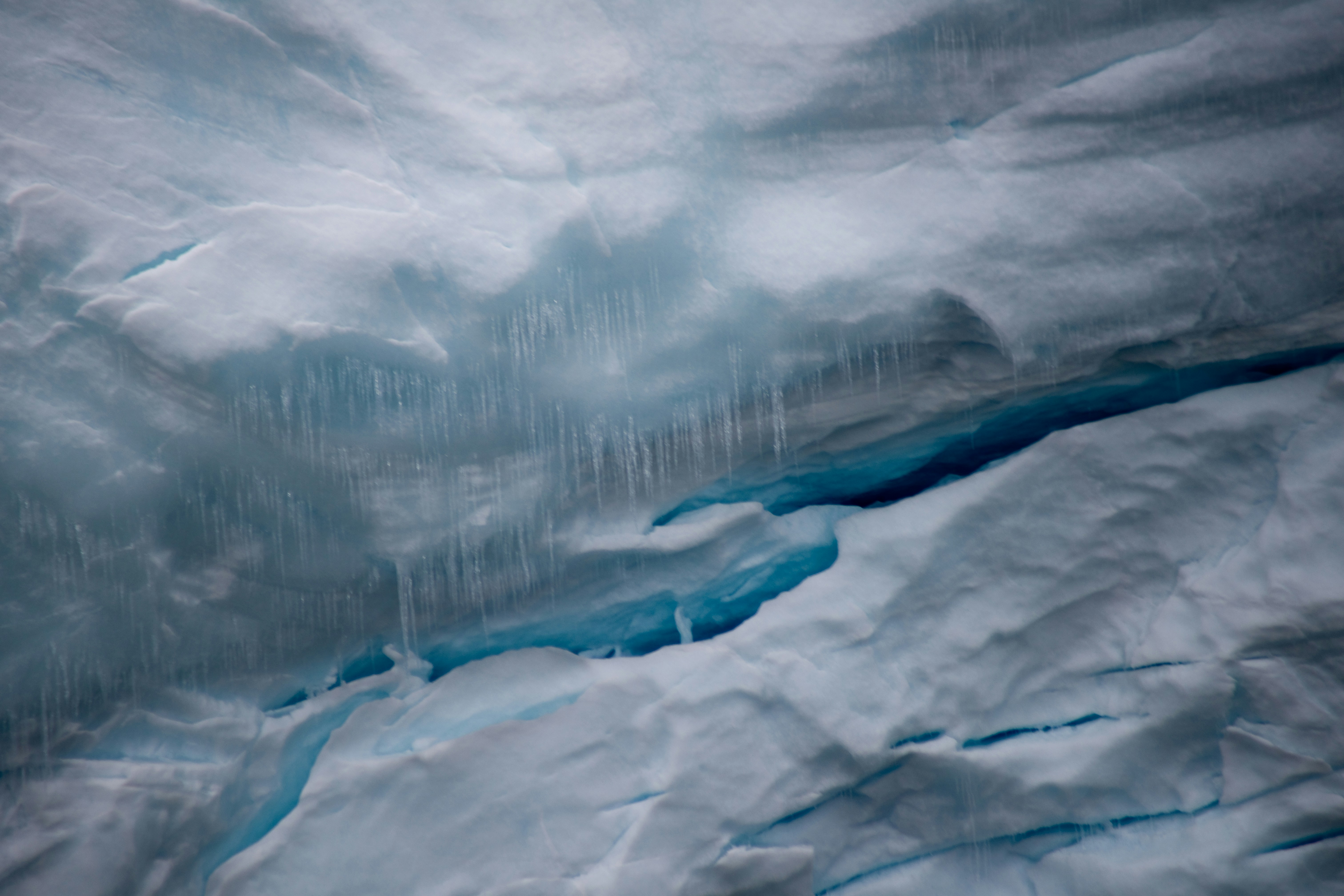 Un gran iceberg con agua azul fluyendo por su costado