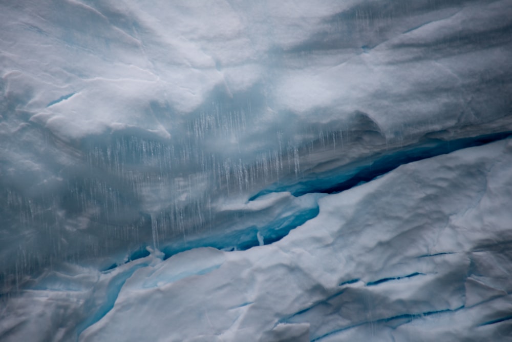 a large iceberg with blue water flowing down it's side