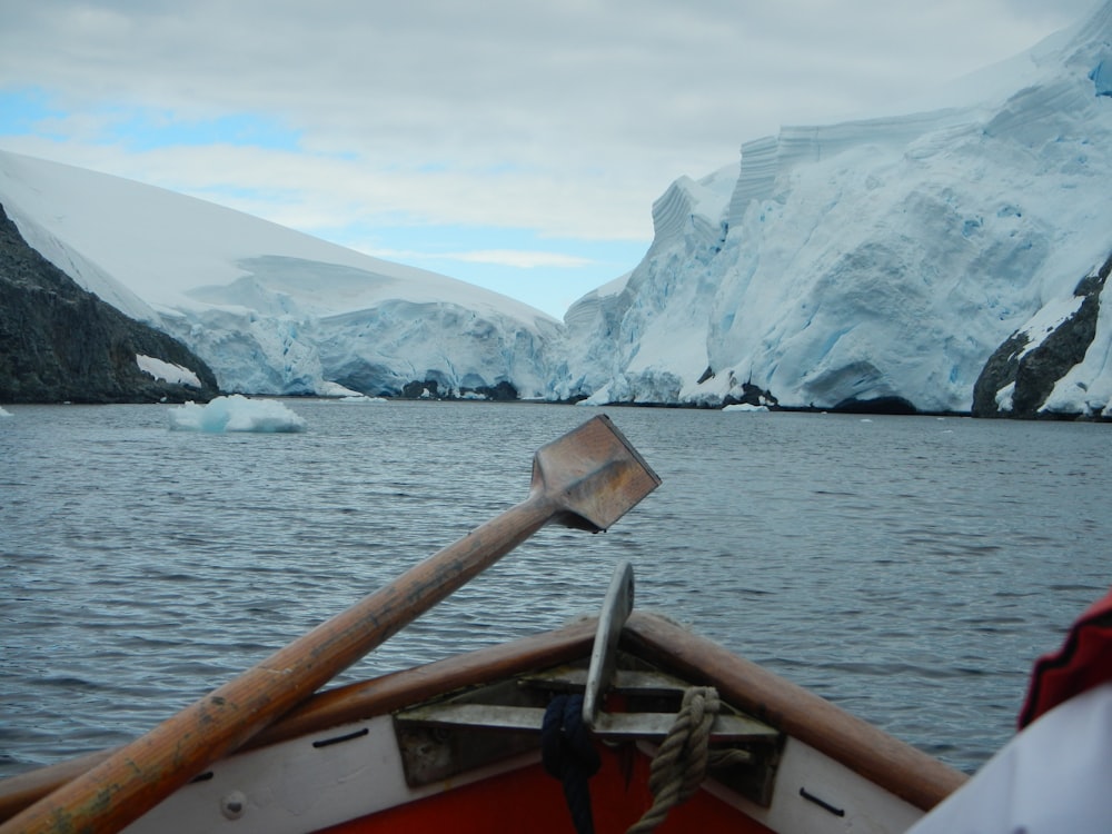 a boat in a body of water with icebergs in the background