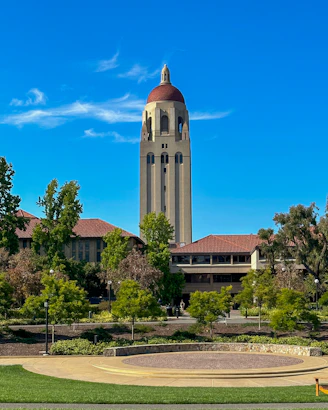 a large building with a clock tower in the middle of a park