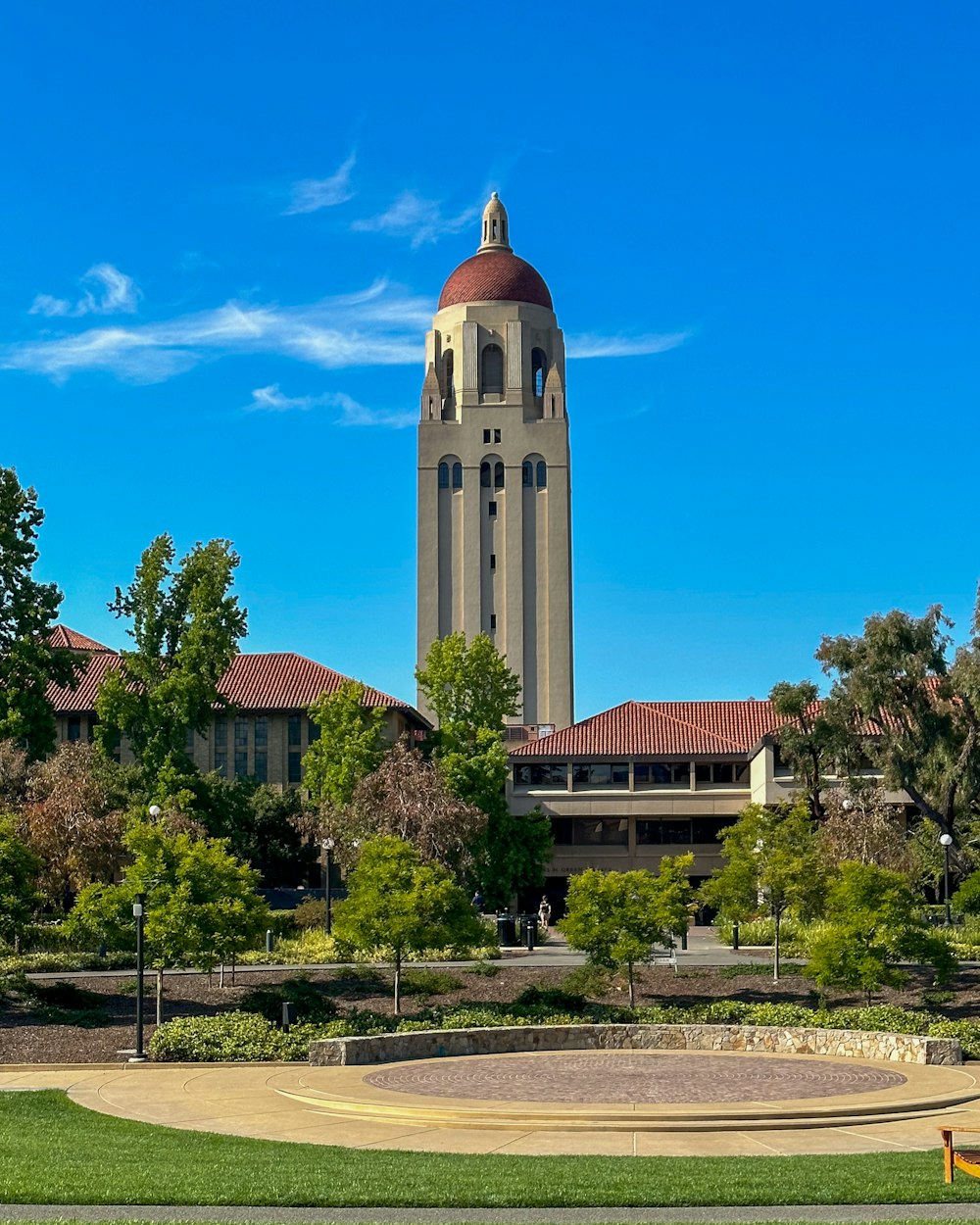 a large building with a clock tower in the middle of a park