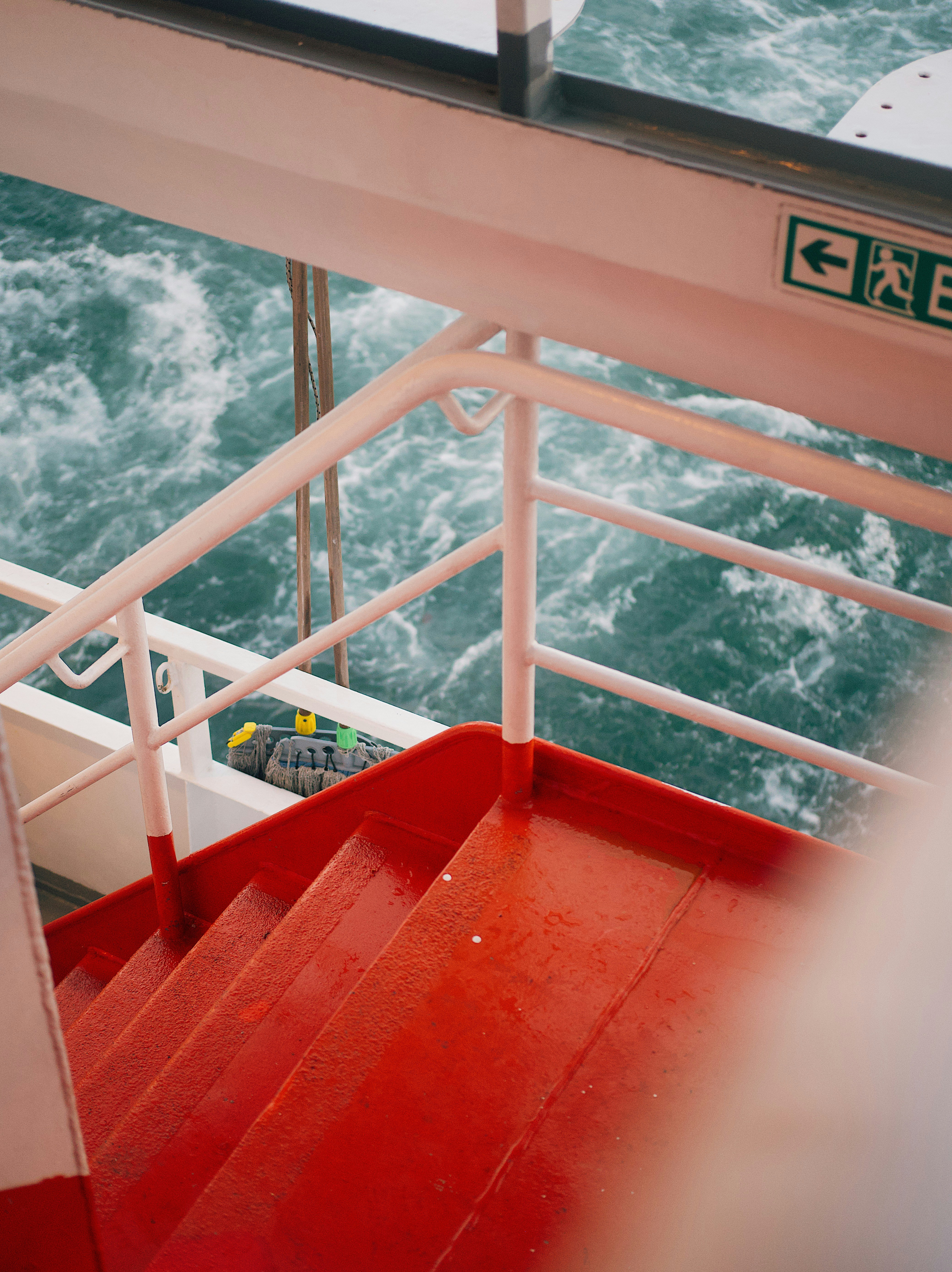 a red staircase going up to the top of a boat