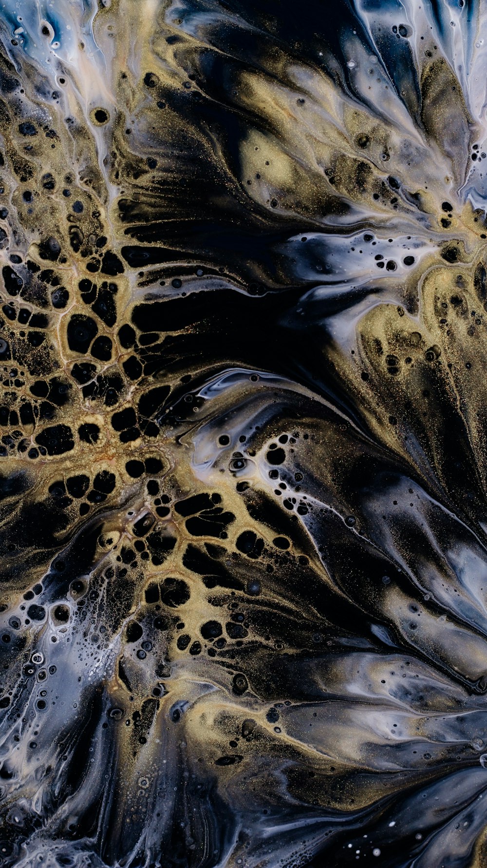 a close up of a black and gold abstract painting