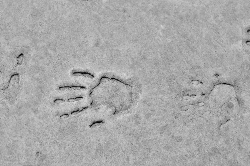 a black and white photo of two footprints in the sand