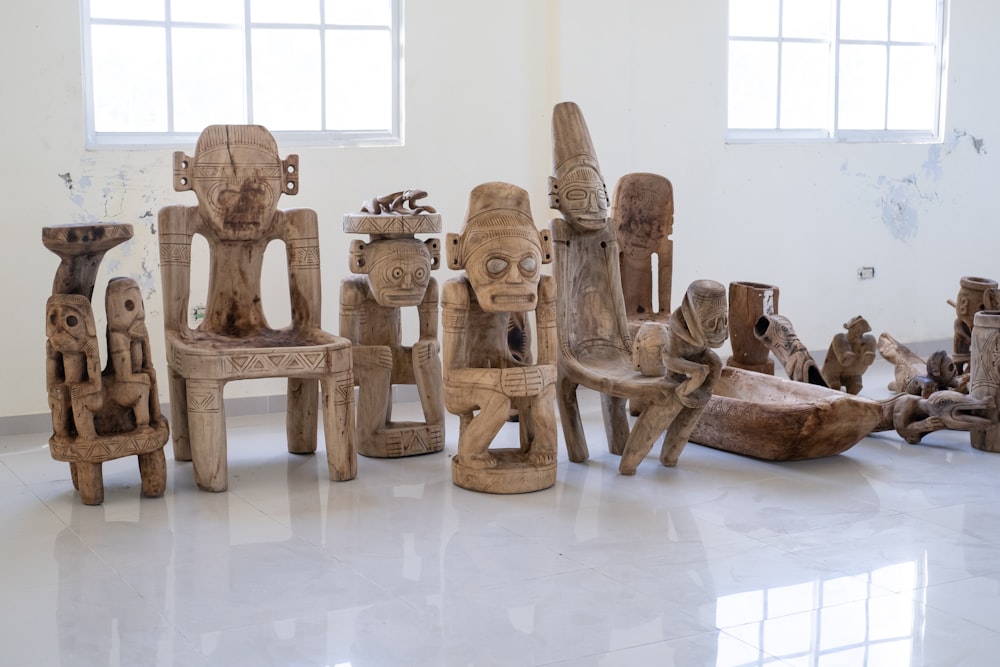 a group of wooden sculptures sitting on top of a white floor