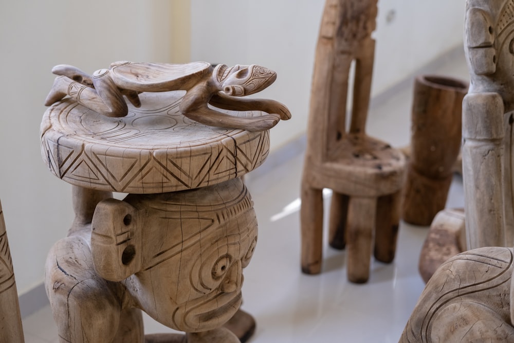 a group of carved wooden chairs and stools