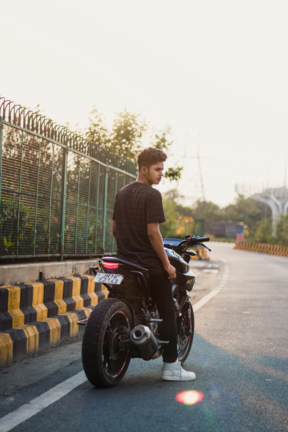 a man riding on the back of a motorcycle down a street