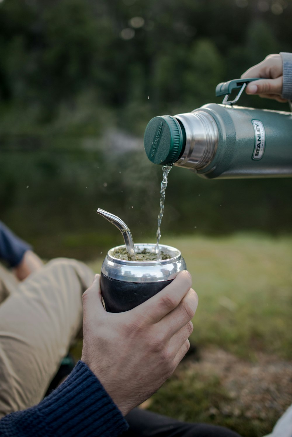 a person is pouring something into a cup