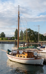 A classic wooden sailboat with polished mahogany finish sailing near the coast of North Carolina.