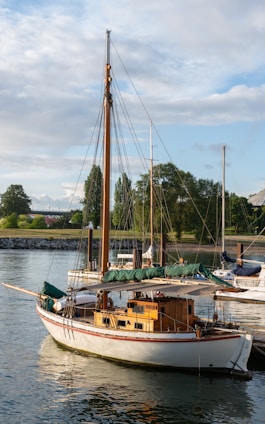 A classic wooden sailboat with polished mahogany finish sailing near the coast of North Carolina.